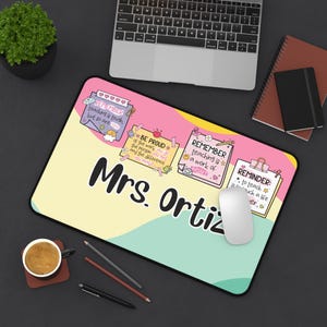 Könnte beinhalten: Ein personalisiertes Mauspad mit einem farbenfrohen Design mit dem Namen "Mrs. Ortiz" in großen schwarzen Buchstaben. Das Mauspad enthält inspirierende Zitate und Erinnerungen für Lehrer. Eine Computermaus liegt auf dem Pad.