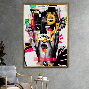 May include: A colorful abstract collage artwork featuring a black and white face with a yellow eye and a pink and black background. The artwork is framed in gold.