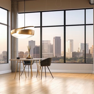 May include: A modern dining room with a gold and white pendant light hanging over a table with two black chairs. The room has large windows with a view of a city skyline.