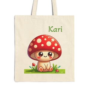 May include: A white canvas tote bag with a red and white mushroom cartoon character and the name "Kari" printed in green text.