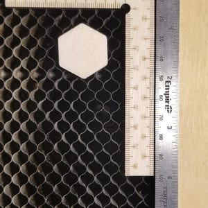 May include: A wooden ruler with a hexagonal cutout, measured with a metal ruler marked in 32nds of an inch. The metal ruler reads "2 Empire" and "TEMPERED".