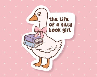 May include: A sticker featuring a cartoon goose with a pink bow carrying two books. The text "the life of a silly book girl" is above the goose. The background is pink with white hearts.