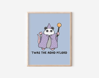 May include: A framed print featuring a cartoon opossum dressed as a wizard, wearing a purple cape with white polka dots and a matching hat. The opossum holds a golden orb on a stick. Text at the bottom reads, "'TWAS THE ADHD M'LORD."
