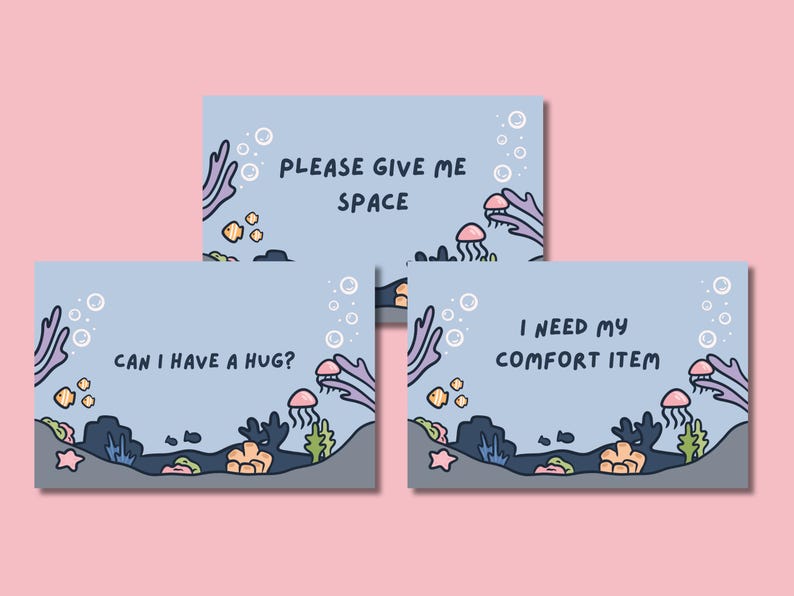 Puede incluir: Tres tarjetas azul claro con un tema submarino. Cada tarjeta tiene un mensaje diferente: "PLEASE GIVE ME SPACE", "CAN I HAVE A HUG?" y "I NEED MY COMFORT ITEM". Las tarjetas presentan ilustraciones de dibujos animados de coral, peces, medusas y burbujas.