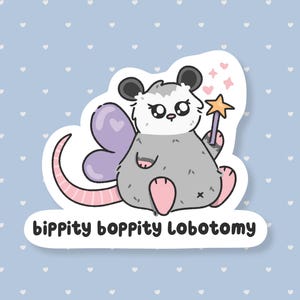 May include: A sticker featuring a cartoon opossum with fairy wings, holding a star wand. The opossum is gray with pink accents and black ears. The sticker has the text "bippity boppity Lobotomy" in a black, rounded font.