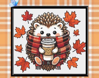 Könnte beinhalten: Gerahmte Illustration eines niedlichen Igels mit einem rot-schwarz karierten Schal, der eine Kaffeetasse mit einem Herzen hält. Das Bild ist von orangefarbenen Ahornblättern und einem blauen Schmetterling umgeben. Der Hintergrund ist ein Karomuster.