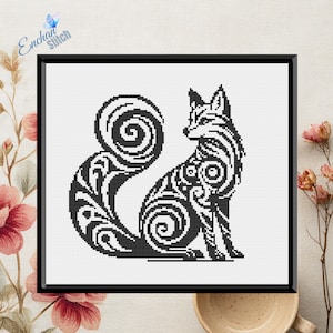 May include: Black and white cross-stitch art of a fox with a decorative, swirling pattern. The fox is seated, with its tail curled. The artwork is framed in a black frame. The text "Enchan Stitch" is in the upper left corner.