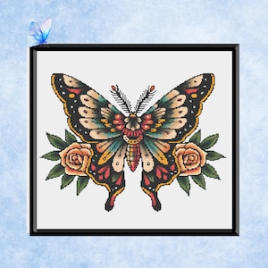 May include: A framed cross-stitch depicting a butterfly with detailed wings in black, yellow, red, and teal. The butterfly is flanked by two peach roses with green leaves. The design includes a floral pattern on the butterfly's body. A small blue butterfly is in the upper left corner.