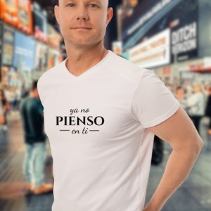 Op de afbeelding: Wit V-hals T-shirt met de tekst "ya no PIENSO -en ti- " in zwart gedrukt.
