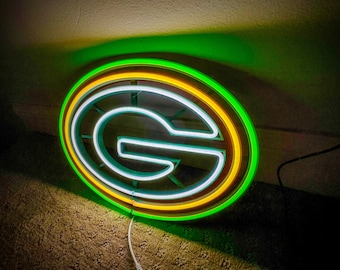 May include: Green and yellow neon sign with the letter "G" inside a circle. The sign is lit up and glowing.