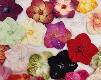 May include: A collection of fabric flowers in various colors including red, blue, purple, yellow, green, and pink. Each flower features five petals with a textured surface and is embellished with small, matching beads and sequins at the center.