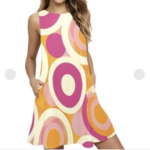 Op de afbeelding: Mouwvrije shiftjurk met een retro-ontwerp. De jurk heeft een patroon van overlappende cirkels in roze, oranje en crème. De jurk heeft zakken en een relaxte pasvorm, perfect voor een casual look.
