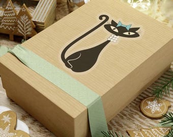 May include: A brown gift box with a green ribbon tied around it. The box features a black and white illustration of a cat wearing a blue bow on its head.