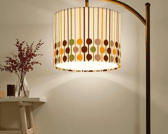 May include: A gold floor lamp with a curved arm and a white lampshade with brown, green, and orange geometric patterns.