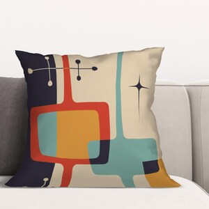 May include: A decorative throw pillow with a mid-century modern geometric design. The pillow features a beige background with abstract shapes in red, orange, blue, and black.
