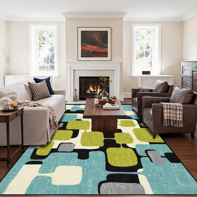 May include: A patterned rug in a living room. The rug has a geometric design with blue, green, black, and cream shapes. It's placed in front of a fireplace, between a sofa and two armchairs. The room has a neutral colour scheme.