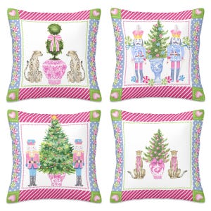May include: Four decorative throw pillows with various designs. One pillow features a topiary and cheetahs, another has nutcrackers and a Christmas tree, and the others have similar holiday themes. Each pillow has a white center with a pink and blue border.