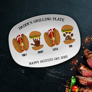 May include: White oval serving platter with the text "Daddy's Grilling Plate" and "Happy Father's Day 2025". Four handprint designs are on the platter, each with a name underneath: Vincy, Johnny, Layla, and Tom.