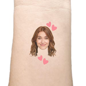 May include: A light-skinned arm with a printed image of a woman's face and three pink hearts. The woman has auburn hair and a smiling expression. Two hearts are above her head, and one is below.