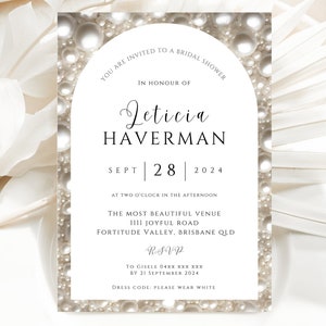 May include: A white bridal shower invitation with a pearl border. The invitation reads "You are invited to a bridal shower in honour of Leticia Haverman, Sept 28, 2024, at two o'clock in the afternoon. The most beautiful venue, 1111 Joyful Road, Fortitude Valley, Brisbane QLD. RSVP to Giselle 04XX XXX XXX by 21 September 2024. Dress code: Please wear white."