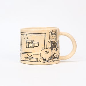 May include: Beige ceramic mug with black line art. The design includes a computer screen, a 2025 calendar, and illustrations of two dogs. The mug has a curved handle and a speckled texture.