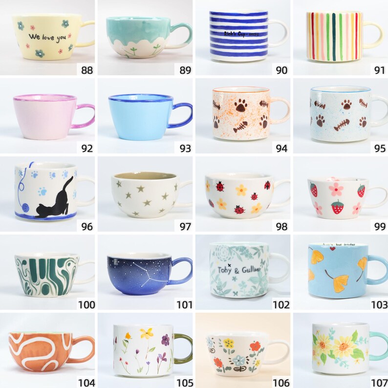May include: A selection of ceramic mugs in diverse colours and designs. Some mugs feature floral patterns, while others have stripes, stars, or cat illustrations. One mug has the text "We love you".