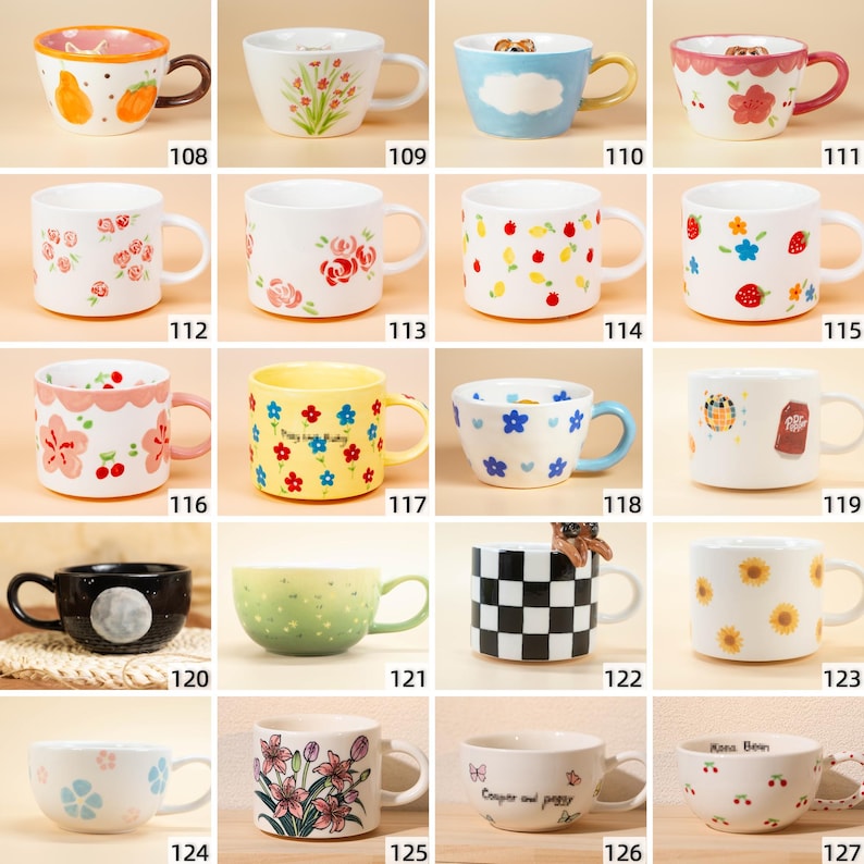 May include: A selection of ceramic mugs with diverse designs. The mugs display floral patterns, fruit illustrations, and other decorative elements. Some mugs have unique handle colours and shapes. The mugs are numbered from 108 to 127.