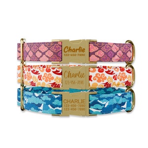 May include: Three personalized dog collars with gold-colored buckles. The collars feature cloud patterns in purple, orange, and blue. Each buckle is engraved with the name "Charlie" and a phone number.