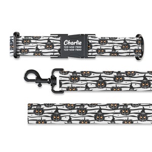 May include: Black and white dog collar and leash with a Halloween pumpkin pattern. The collar has a black buckle with the name "Charlie" and phone number "123-456-7890" printed on it.