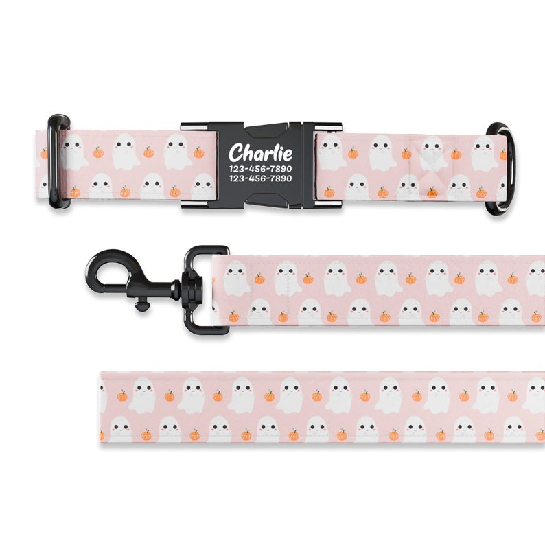 May include: Pink dog collar and leash with a pattern of white ghosts and orange pumpkins. The collar has a black buckle with the name "Charlie" and phone number "123-456-7890" printed on it.