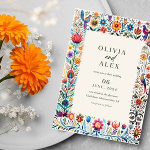 May include: Wedding invitation with a colorful floral border and the text "Olivia and Alex invite you to their wedding June 06, 2024 two o'clock in the afternoon Clock Barn, Gloucestershire, UK reception to follow"