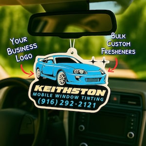 May include: A light blue car-shaped air freshener hanging from a car's rearview mirror. The air freshener features a car graphic and the text "KEITHSTON MOBILE WINDOW TINTING (916) 292-2121". Text on the left says "Your Business Logo" and on the right "Bulk Custom Fresheners".
