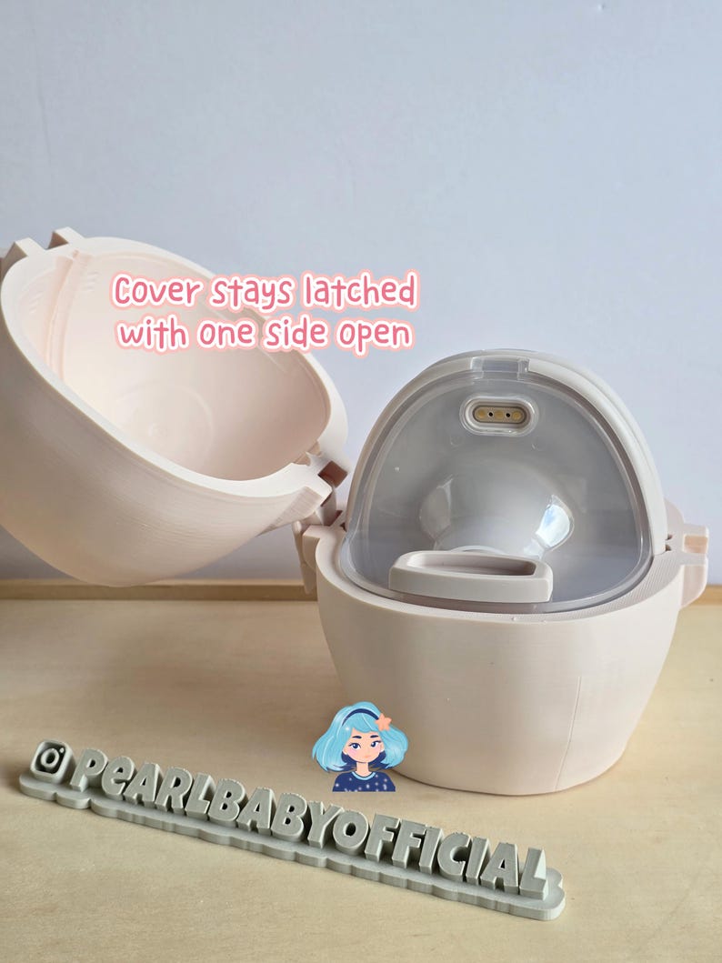 K&ouml;nnte beinhalten: Eine hellrosa Babyflasche mit einem durchsichtigen, gew&ouml;lbten Deckel. Die Flasche ist ge&ouml;ffnet und zeigt das Innere. Der Text auf dem Bild lautet "Cover stays latched with one side open." Ein graues Schild mit "@PEARLBABYOFFICIAL" befindet sich unten.