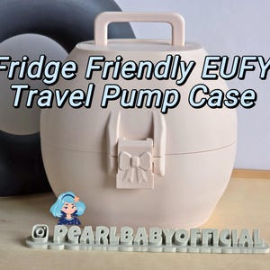 May include: A light pink, oval-shaped travel pump case with a handle and a bow-shaped clasp. The text "Fridge Friendly EUFY Travel Pump Case" is displayed on the case. The case is designed to be fridge-friendly.