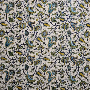 May include: A white fabric with a repeating pattern of blue, green, and yellow floral designs. The pattern is intricate and detailed, featuring stylized leaves, flowers, and paisley shapes.