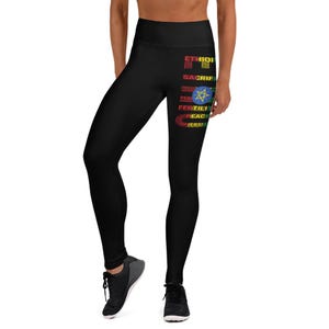 May include: Black high-waisted leggings with text and a flag design. The text includes words like "Ethiopia", "Sacrifice", "Peace", "Fertility", and "Diversity". The leggings are made of a stretchy material.
