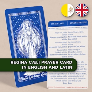 Può includere: Una carta di preghiera blu con un'illustrazione bianca di Maria e Gesù, e il testo "Regina Caeli" in inglese e latino. La carta ha un bordo decorativo ed è accompagnata da una seconda carta con il testo della preghiera.