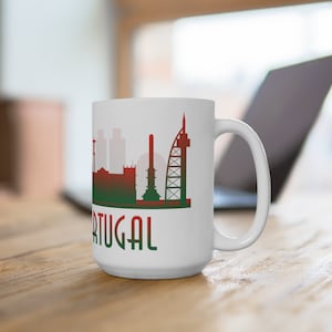 May include: White ceramic mug with a red, green, and white silhouette of a city skyline and the word "PORTUGAL" printed on the front.
