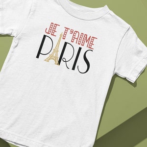 A tshirt that says "Je T'aime Paris". The A in "Paris" is replaced with a graphic of the Eiffel Tower.