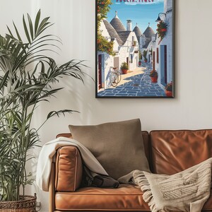 May include: A vintage travel poster featuring a narrow street in Alberobello, Puglia, Italy. The street is lined with white trulli houses, traditional conical-roofed buildings, and a bicycle is parked on the cobblestone street.