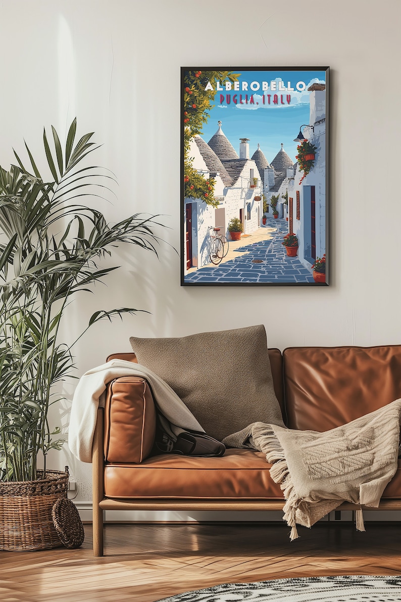May include: A vintage travel poster featuring a narrow street in Alberobello, Puglia, Italy. The street is lined with white trulli houses, traditional conical-roofed buildings, and a bicycle is parked on the cobblestone street.