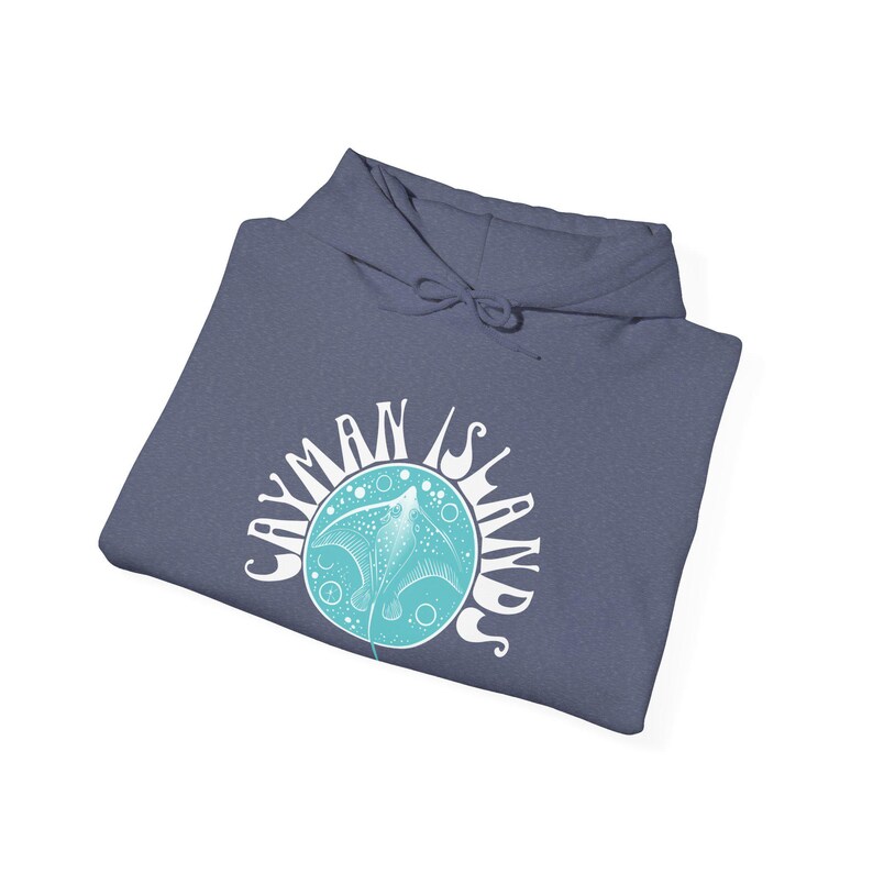 May include: A blue hoodie with the words "CAYMAN ISLANDS" in a white, circular design. The design features a turquoise stingray illustration. The hoodie is folded, showing the hood and drawstring.