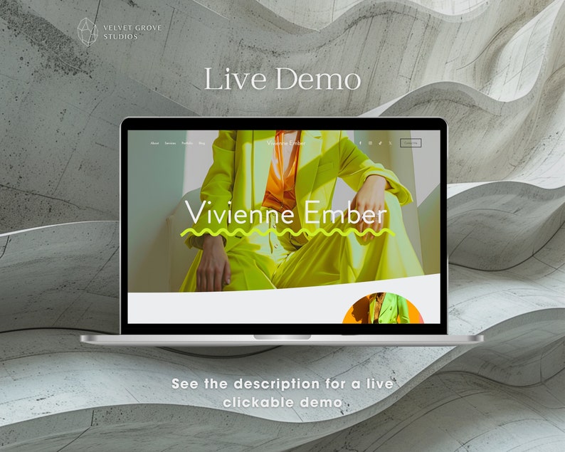 May include: A laptop computer displaying a website with the text "Vivienne Ember" in a yellow and white wavy design. The website is on a white background with a gray and white textured background behind the laptop.