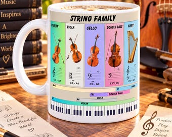 May include: A white ceramic mug featuring a colorful graphic labeled STRING FAMILY, displaying illustrations of a violin, viola, cello, double bass, and harp with their respective musical clefs, note ranges, and a piano keyboard at the base.