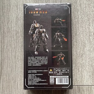Może przedstawiać: Opakowanie figurki Iron Man Mark 1. Pudełko zawiera zdjęcia figurki w r&oacute;żnych pozach, z logo Marvel Studios. Figurka to szczeg&oacute;łowy, metaliczny przedmiot kolekcjonerski.