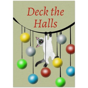 May include: A light green greeting card featuring the red text Deck the Halls. A white and grey cat hangs from a black curved line, surrounded by colorful hanging spherical ornaments in yellow, silver, green, red, and blue.