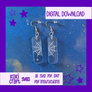 Könnte beinhalten: Transparente, rechteckige Ohrringe mit einem weißen Spinnennetz-Design und einer kleinen Spinne. Die Ohrringe hängen an silberfarbenen Haken. Das Bild enthält auch den Text "DIGITAL DOWNLOAD" und "koki craft svgs .ai .svg .pdf .dxf PDF instructions" auf blauem Hintergrund.