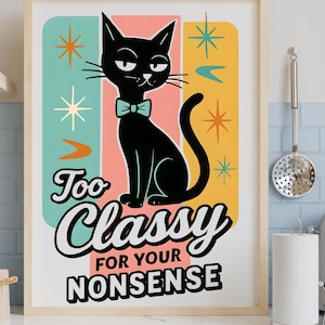 May include: A framed art print featuring a black cat with a teal bow tie, set against a retro background of teal, coral, and yellow. The print includes the text "Too Classy for your Nonsense" in a playful font. The artwork is displayed in a kitchen setting.