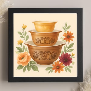 May include: A framed print featuring three nested brown mixing bowls with white interiors. The bowls are decorated with fruit and floral designs. The background is a light beige with colorful flowers and green leaves surrounding the bowls.