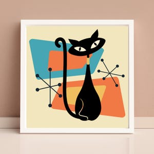 May include: A framed print featuring a stylized black cat with a long tail, set against a mid-century modern background. The background includes geometric shapes in teal, orange, and yellow, with starburst accents. The artwork is set against a cream-colored backdrop.